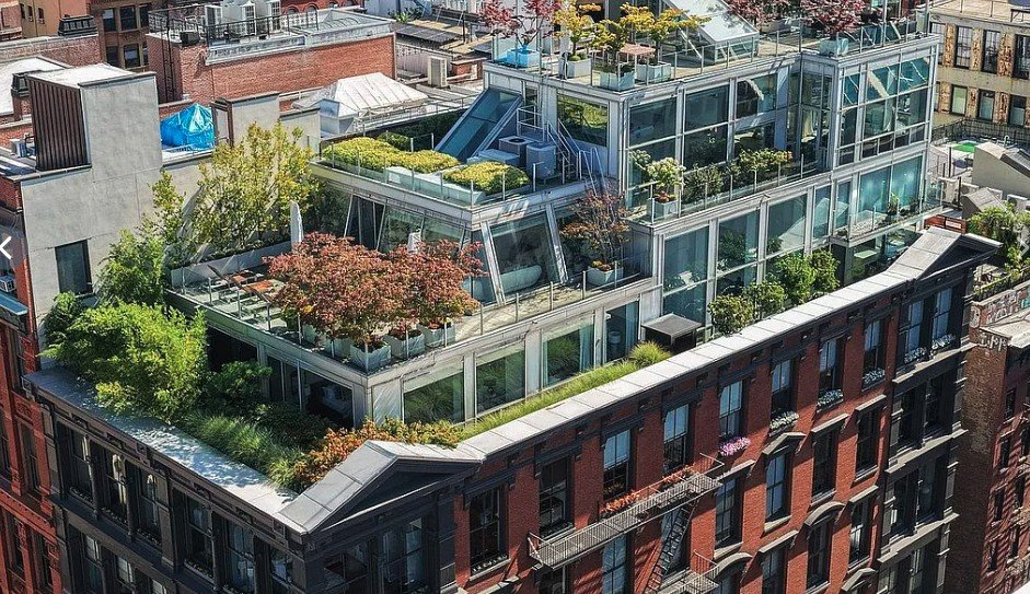 Aerial view of the glass penthouse and its planted terraces atop the red brick and cast-iron building